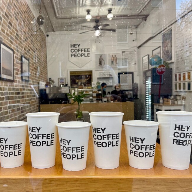 coffee cups lined up that say 'hey coffee people' 