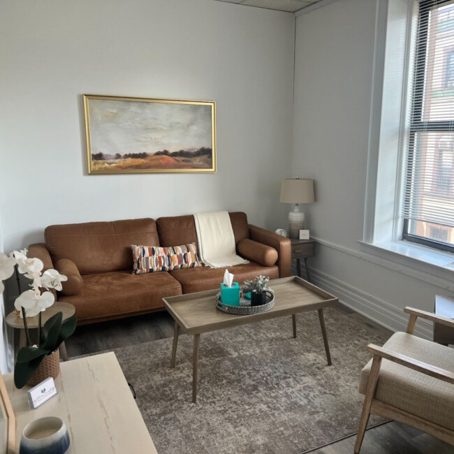 Hoboken Wellness Counseling room with couch, table, and window