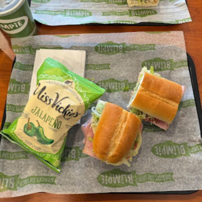 Aerial shot of Blimpie sandwhich and bag of chips on Blimpie wrapper
