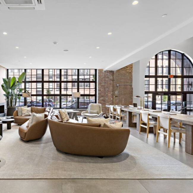 Large windows, long table, and couches in Wonder Lofts lobby