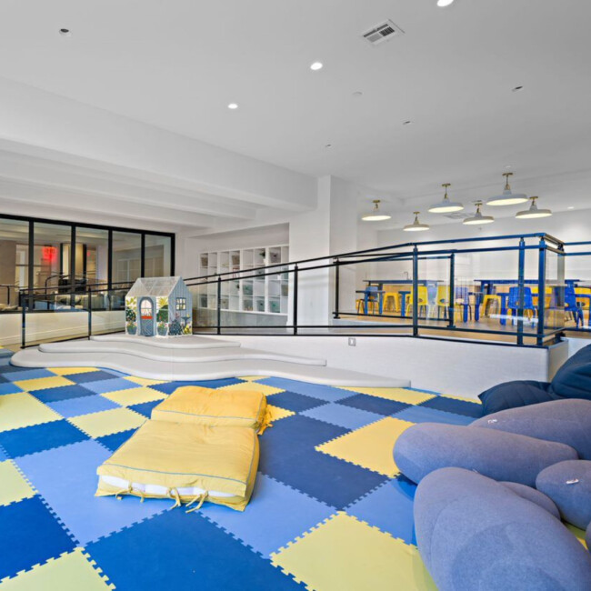 Children's playroom with blue and yellow flooring and pillows
