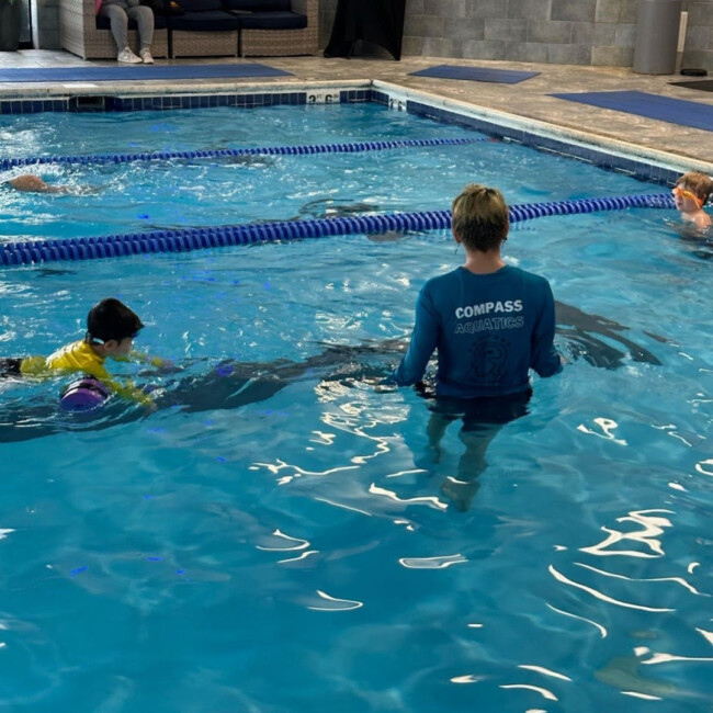 COMPASS aquatics instructor in a pool with students