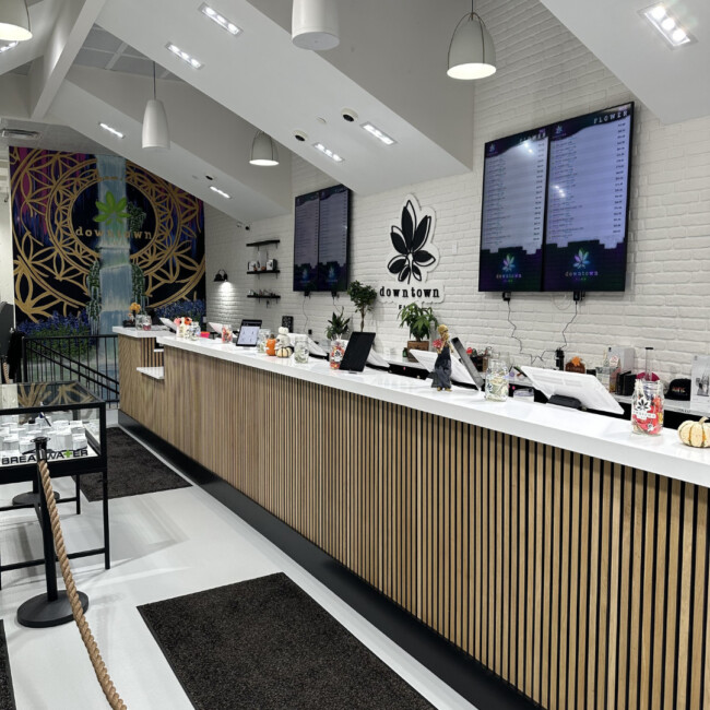 Checkout counter at downtown FLWR with screens and a sign that reads "downtown FLWR" hanging on the back wall
