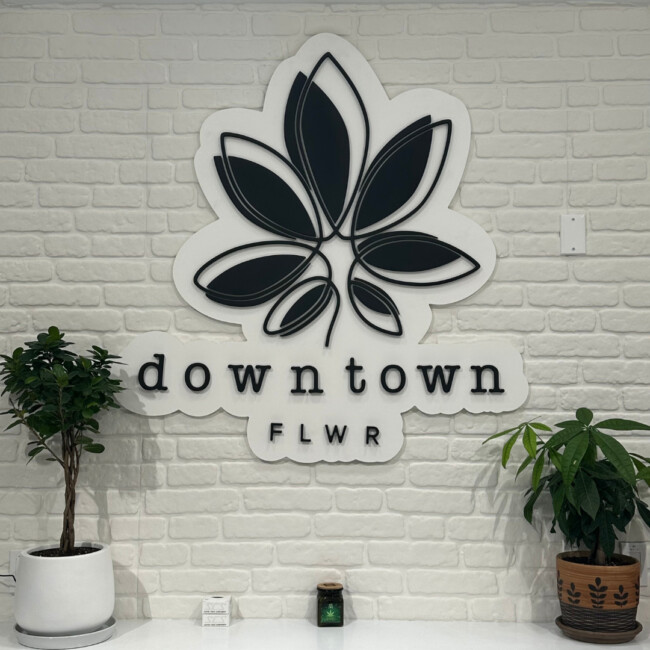 downtown FLWR logo on a white brick wall