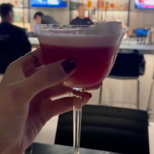 Hand holding a pink cocktail